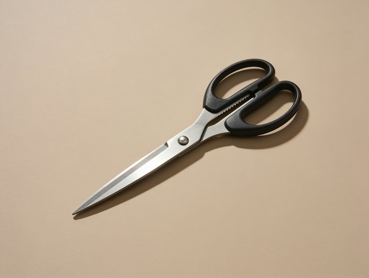 A pair of scissors resting on a bare working surface